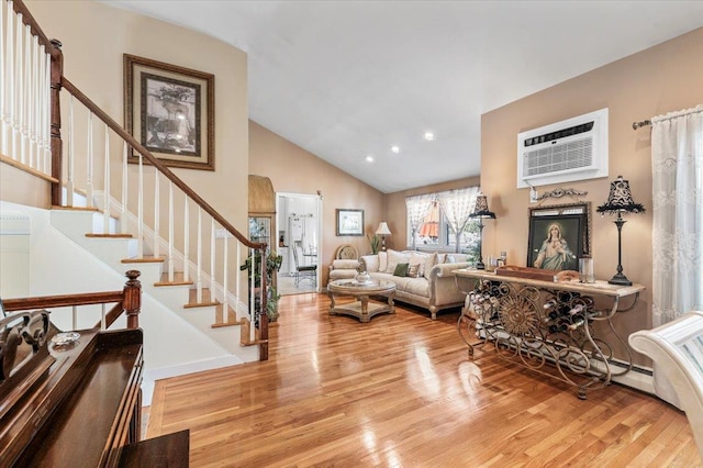 2406 Kayron Ln, North Bellmore, NY 11710 - living area featuring wood finished floors, an AC wall unit, stairs, high vaulted ceiling, and recessed lighting