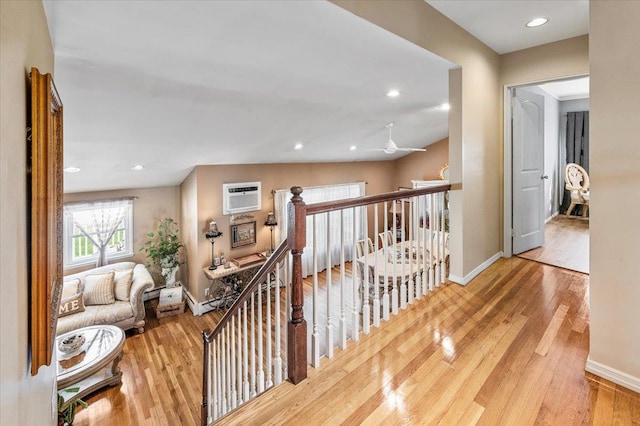 2406 Kayron Ln, North Bellmore, NY 11710 - hall with an upstairs landing, wood finished floors, a wall unit AC, baseboards, and recessed lighting