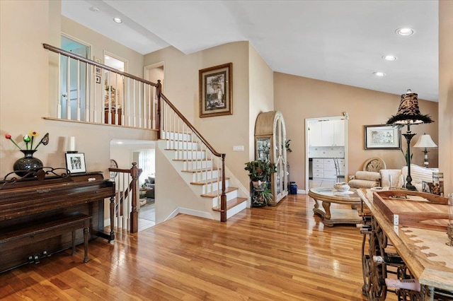 2406 Kayron Ln, North Bellmore, NY 11710 - living area with light wood-style floors, stairs, recessed lighting, baseboards, and high vaulted ceiling