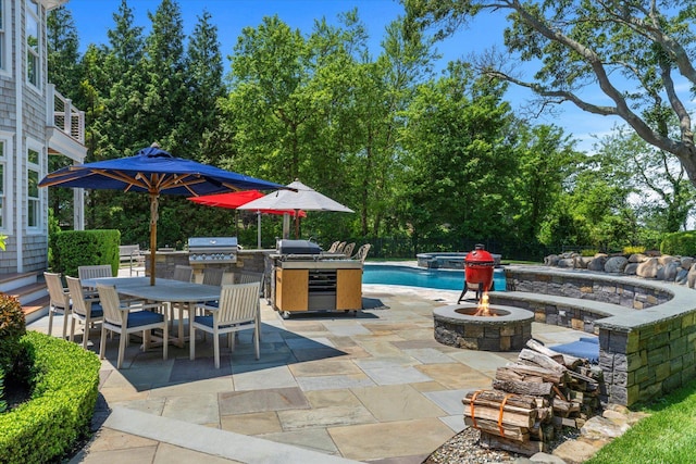 321 Sandpiper Dr, Riverhead, NY 11901 - view of patio / terrace featuring outdoor dining space, a fire pit, exterior kitchen, an outdoor pool, and view of scattered trees