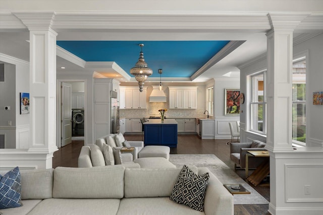 321 Sandpiper Dr, Riverhead, NY 11901 - living area featuring ornate columns, washer / clothes dryer, a decorative wall, dark wood finished floors, and ornamental molding