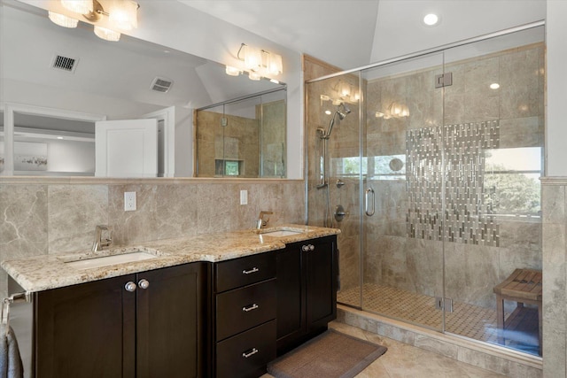 321 Sandpiper Dr, Riverhead, NY 11901 - bathroom featuring a stall shower, double vanity, lofted ceiling, tile patterned floors, and tile walls