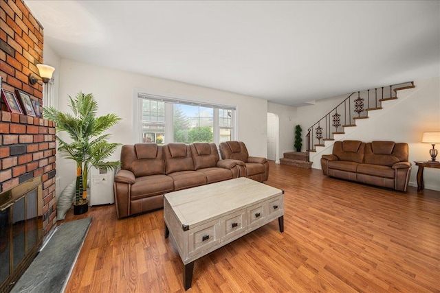 769 De Mott Ave, North Baldwin, NY 11510 - living area featuring a fireplace, stairway, light wood finished floors, and arched walkways