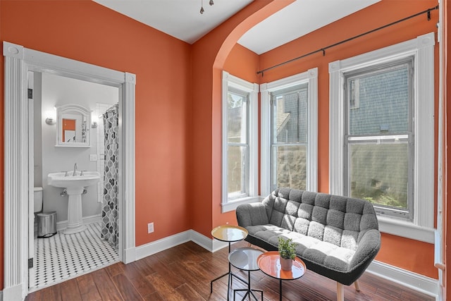 213 Walnut St, Peekskill, NY 10566 - sitting room featuring arched walkways, dark wood-style flooring, baseboards, and healthy amount of natural light