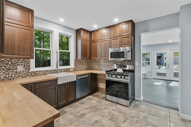 213 Walnut St, Peekskill, NY 10566 - kitchen with stainless steel appliances, a sink, butcher block countertops, backsplash, and recessed lighting