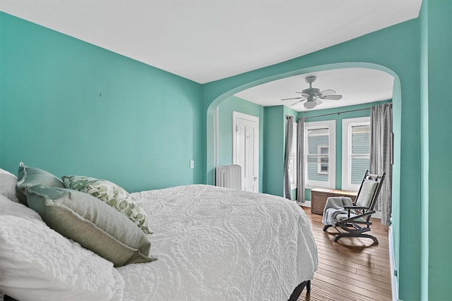 213 Walnut St, Peekskill, NY 10566 - bedroom featuring arched walkways, hardwood / wood-style flooring, radiator, and ceiling fan