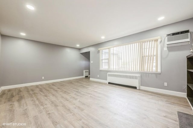 2600 Haff Ave, North Bellmore, NY 11710 - unfurnished living room with radiator heating unit, a wall unit AC, baseboards, wood finished floors, and recessed lighting