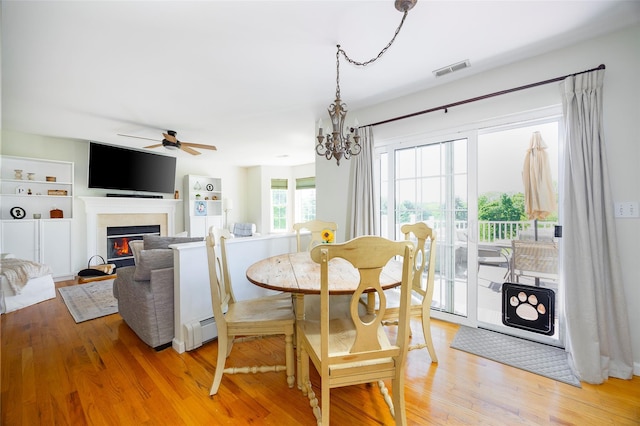 100 Meadow Ridge Ln, Lagrangeville, NY 12540 - dining area with ceiling fan, light wood-type flooring, a baseboard radiator, a glass covered fireplace, and a chandelier