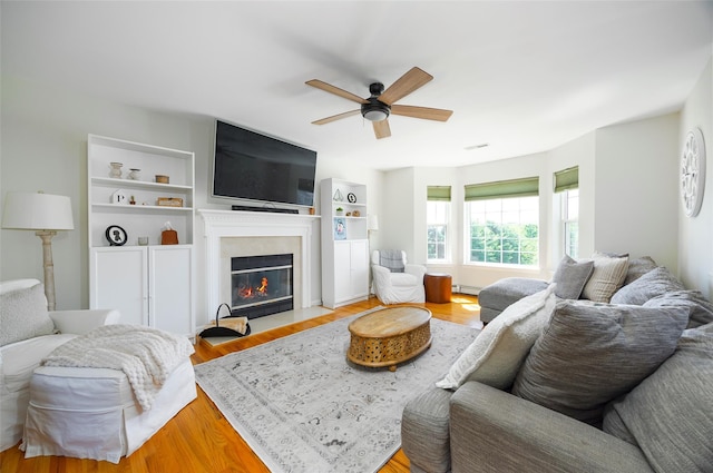 100 Meadow Ridge Ln, Lagrangeville, NY 12540 - living room featuring a ceiling fan, a fireplace with flush hearth, wood finished floors, and baseboard heating