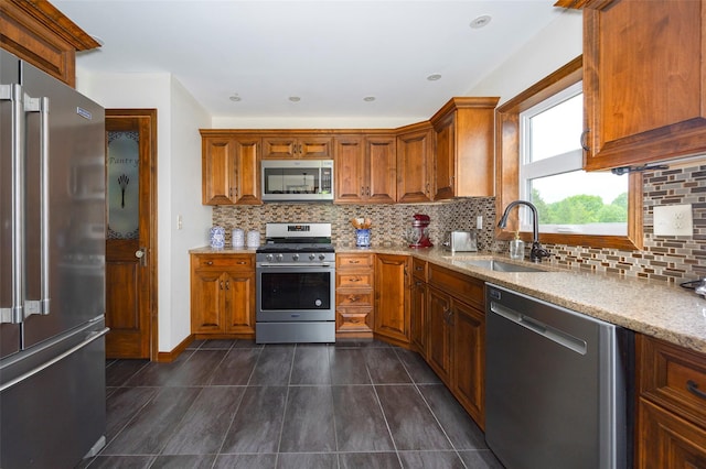 186 Oswego Rd, Pleasant Valley, NY 12569 - kitchen featuring appliances with stainless steel finishes, a sink, brown cabinets, and light stone counters