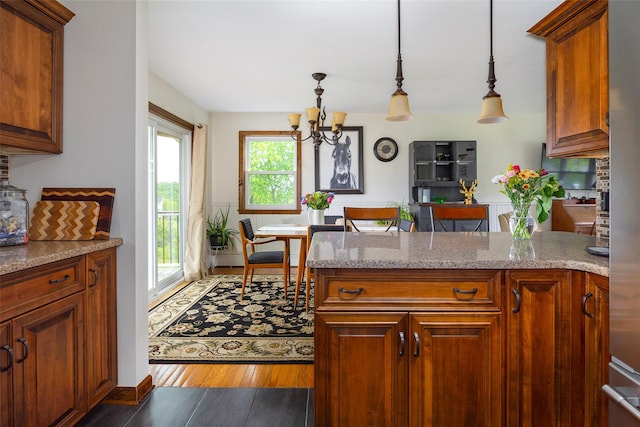 186 Oswego Rd, Pleasant Valley, NY 12569 - kitchen featuring a chandelier, wood finished floors, a peninsula, hanging light fixtures, and brown cabinetry