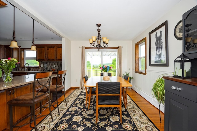186 Oswego Rd, Pleasant Valley, NY 12569 - dining space with a chandelier, wood finished floors, baseboards, and a baseboard heating unit