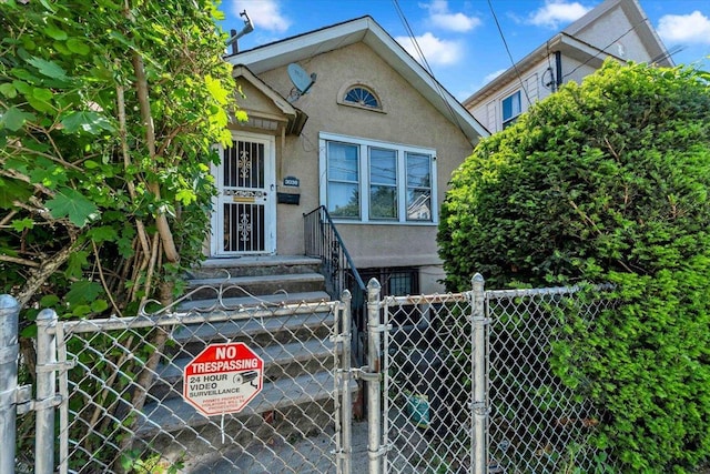 3038 Tiemann Ave, Bronx, NY 10469 - view of front facade with stucco siding and a gate