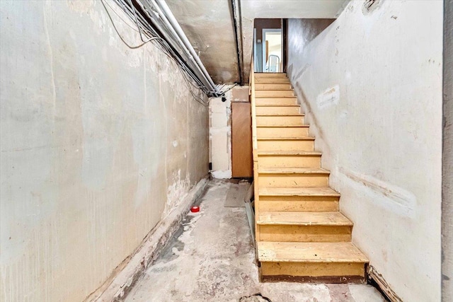 3038 Tiemann Ave, Bronx, NY 10469 - staircase featuring unfinished concrete flooring