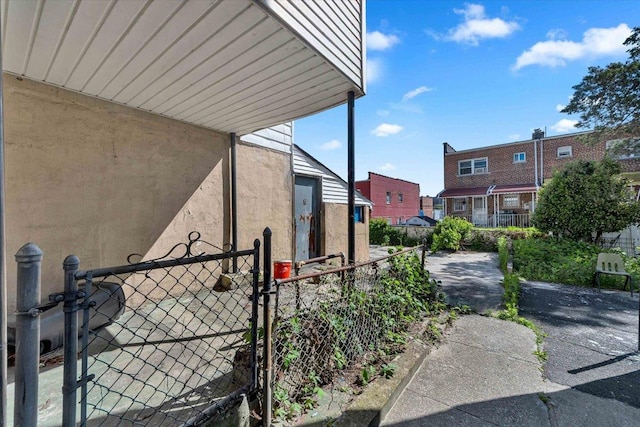 3038 Tiemann Ave, Bronx, NY 10469 - view of property exterior featuring stucco siding, a gate, and a residential view