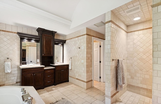 10 Colonial Dr, Smithtown, NY 11787 - full bathroom with double vanity, tile walls, tile patterned floors, crown molding, and a bathtub
