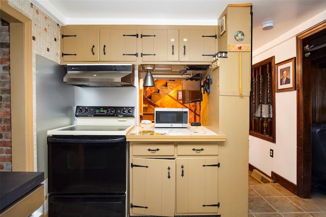 20 Division St, Cold Spring, NY 10516 - kitchen with under cabinet range hood, electric range oven, stainless steel microwave, light countertops, and baseboards