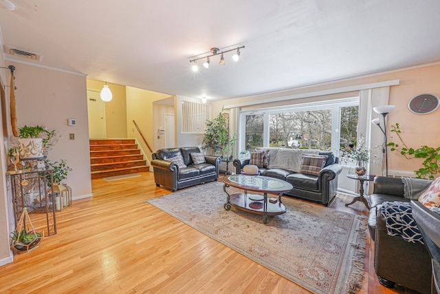 216 Birch Dr, New Hyde Park, NY 11040 - living room featuring wood finished floors, stairs, baseboards, and crown molding