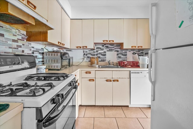49 Ruth Ct, Middletown, NY 10940 - kitchen with white appliances, under cabinet range hood, light countertops, cream cabinetry, and decorative backsplash