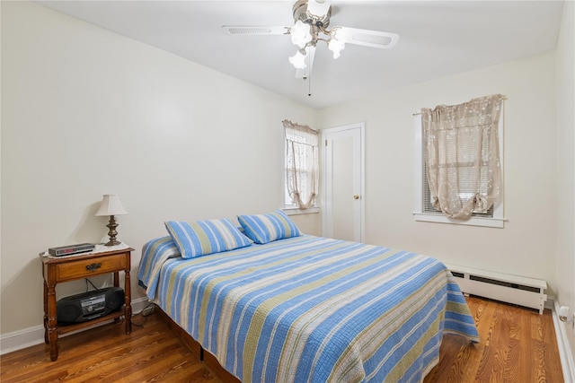624 Westminster Rd, Baldwin, NY 11510 - bedroom with baseboard heating, wood finished floors, ceiling fan, and baseboards
