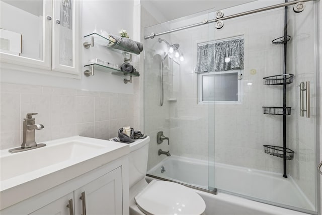 624 Westminster Rd, Baldwin, NY 11510 - bathroom with shower / bath combination with glass door, toilet, vanity, and tile walls