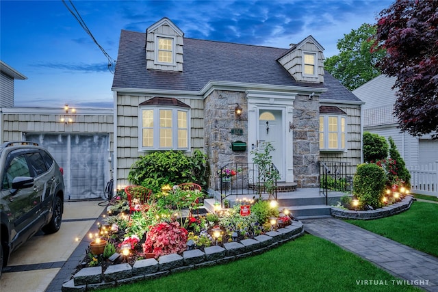 624 Westminster Rd, Baldwin, NY 11510 - cape cod-style house with stone siding, a shingled roof, a front yard, an attached garage, and driveway