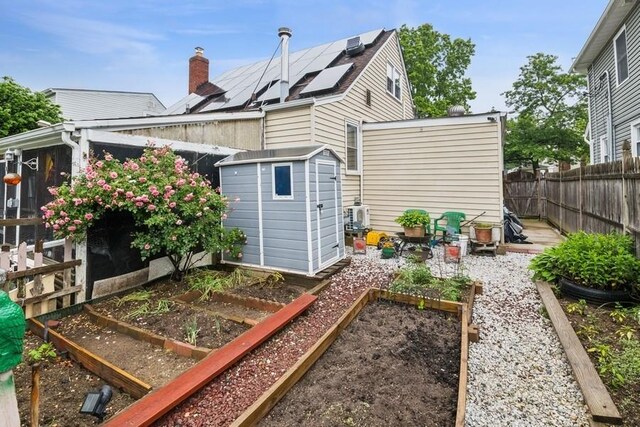 624 Westminster Rd, Baldwin, NY 11510 - rear view of property featuring a garden, solar panels, and a fenced backyard