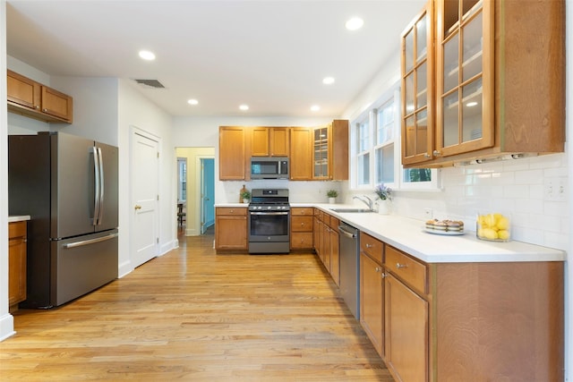 7 Ravine Dr, Hastings-On-Hudson, NY 10706 - kitchen featuring appliances with stainless steel finishes, a sink, light wood-style flooring, brown cabinets, and recessed lighting