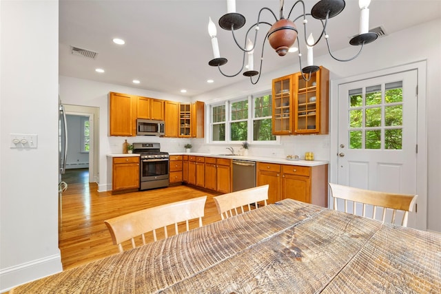 7 Ravine Dr, Hastings-On-Hudson, NY 10706 - kitchen featuring appliances with stainless steel finishes, a sink, a baseboard heating unit, light wood-style flooring, and plenty of natural light