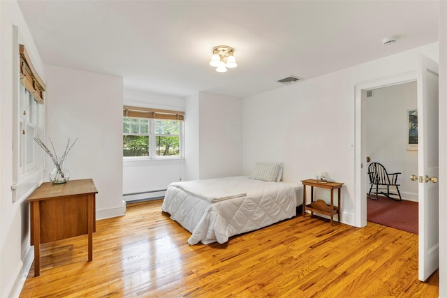 7 Ravine Dr, Hastings-On-Hudson, NY 10706 - bedroom featuring a baseboard heating unit, light wood-style floors, and baseboards