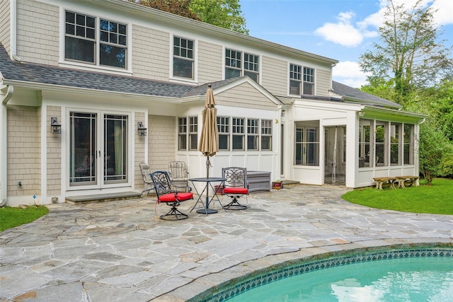 68 Greenhaven Rd, Rye, NY 10580 - back of property with a patio, a sunroom, a shingled roof, and an outdoor pool