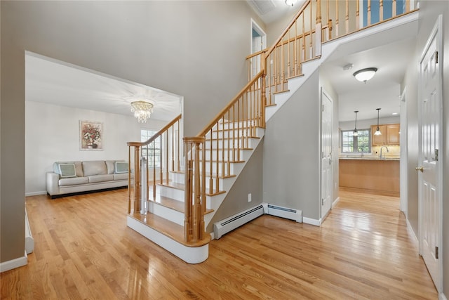 15 Prestwick Dr, Monroe, NY 10950 - stairway with wood finished floors, a high ceiling, a chandelier, baseboard heating, and baseboards
