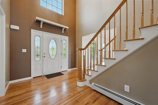 15 Prestwick Dr, Monroe, NY 10950 - entryway with a baseboard radiator, a towering ceiling, wood finished floors, baseboards, and stairway