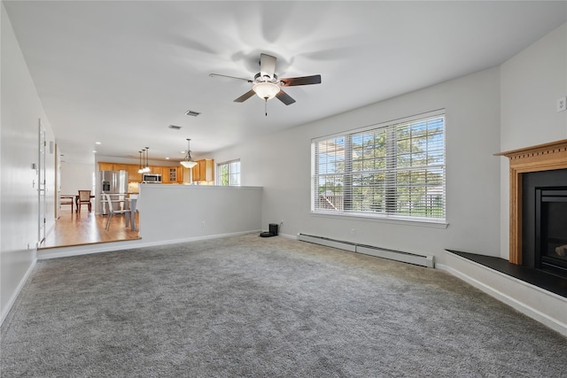 15 Prestwick Dr, Monroe, NY 10950 - unfurnished living room featuring baseboard heating, ceiling fan, carpet flooring, baseboards, and a fireplace with raised hearth