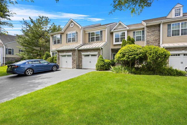 837 Huntington Dr Unit 152, Fishkill, NY 12524 - townhome / multi-family property with driveway, stone siding, a standing seam roof, an attached garage, and a front lawn