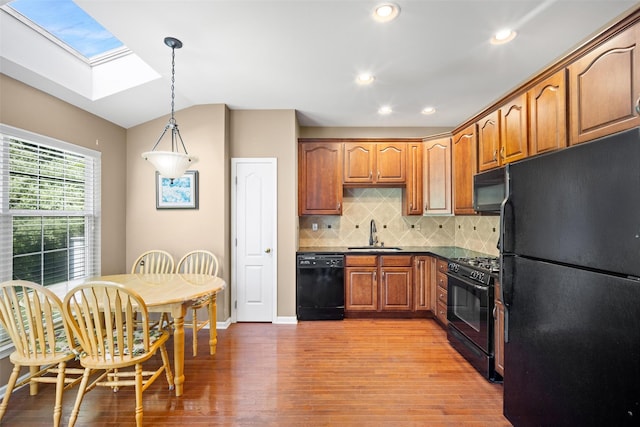 837 Huntington Dr Unit 152, Fishkill, NY 12524 - kitchen with black appliances, a skylight, a sink, light wood-style flooring, and dark countertops