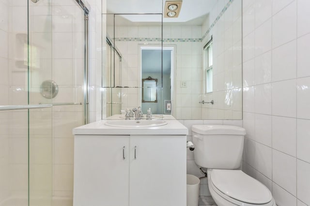 409 Jordan St, Oceanside, NY 11572 - full bathroom featuring tile walls, toilet, a stall shower, and vanity