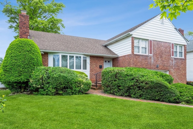 409 Jordan St, Oceanside, NY 11572 - view of front facade with a chimney, a front yard, brick siding, and roof with shingles