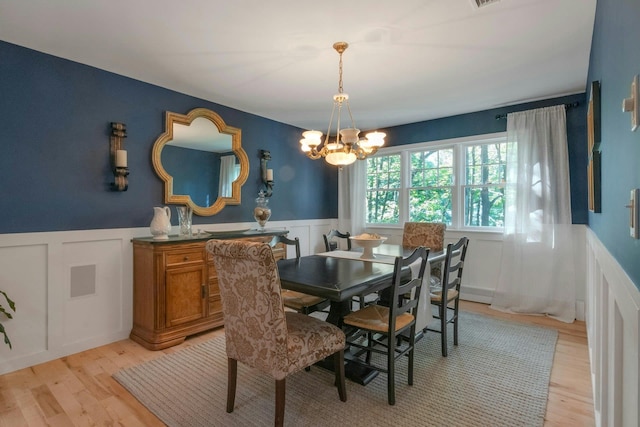 416 Sleepy Hollow Rd, Briarcliff Manor, NY 10510 - dining space with a decorative wall, a wainscoted wall, a chandelier, and light wood-type flooring