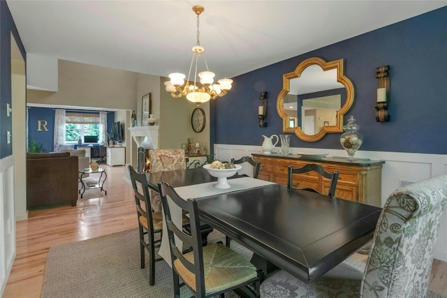 416 Sleepy Hollow Rd, Briarcliff Manor, NY 10510 - dining room featuring a wainscoted wall, a chandelier, light wood-type flooring, and a decorative wall