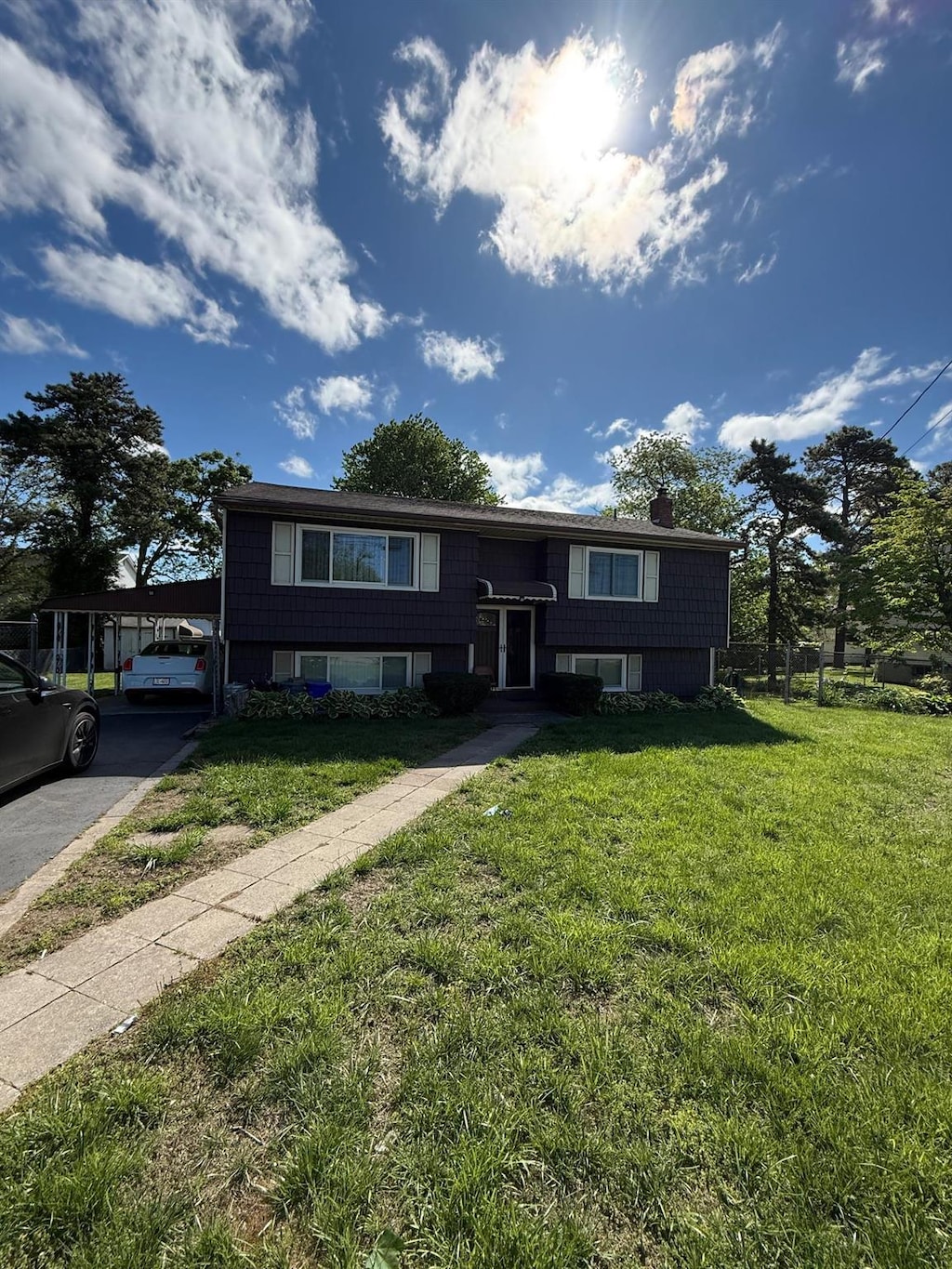 75 S 32nd St, Wyandanch, NY 11798 - split foyer home featuring a front yard, an attached carport, and a chimney