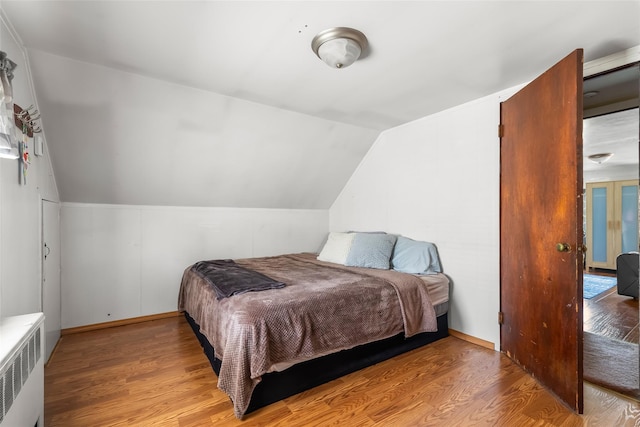98 Bluespruce Rd, Levittown, NY 11756 - bedroom with vaulted ceiling, wood finished floors, and radiator