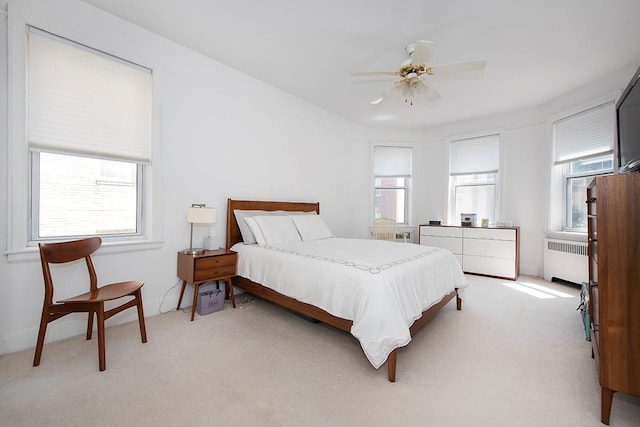 35-53 77th St Unit 5H, Jackson Heights, NY 11372 - bedroom with radiator heating unit, light carpet, and a ceiling fan