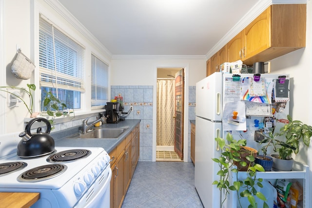 137C Shore Rd, Mount Sinai, NY 11766 - kitchen with white appliances, a sink, light tile patterned floors, brown cabinets, and crown molding