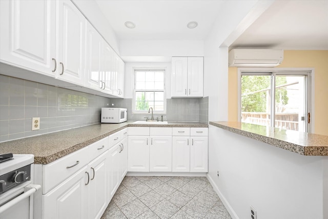 21-22 150th St, Whitestone, NY 11357 - kitchen with white appliances, a wall mounted air conditioner, a sink, backsplash, and white cabinetry