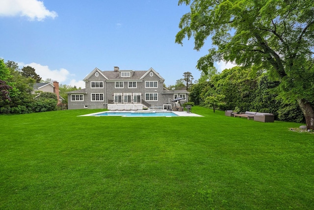 1015 Seven Oaks Ln, Mamaroneck, NY 10543 - back of property with an outdoor pool, a yard, and an outdoor hangout area