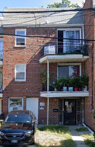 84-03A Chapin Pkwy, Jamaica Hills, NY 11432 - view of front of house with brick siding and a balcony