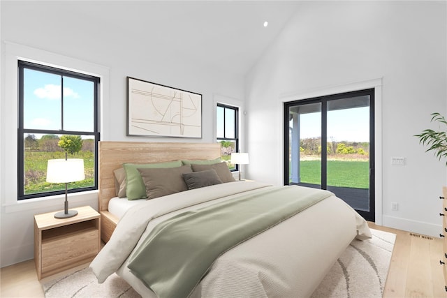 35 Club Dr, Baiting Hollow, NY 11933 - bedroom featuring access to exterior, high vaulted ceiling, wood finished floors, and baseboards