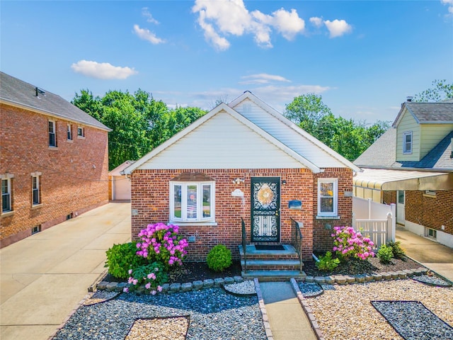 view of front of house featuring brick siding and a detached garage