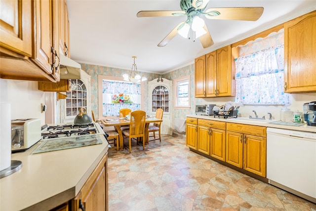 kitchen featuring white dishwasher, a sink, light countertops, and wallpapered walls